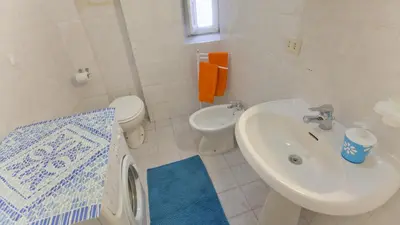 a white bathroom with a sink and a toilet at Rental in Rome Sardegna Apartment in Rome