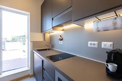 a kitchen with a counter with a sink and a window at Argentina Penthouse by Rental in Rome in Rome