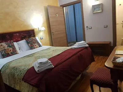 a hotel room with a bed with towels on it at Aurelia Garden Gold B&B in Rome