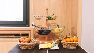 a counter with three baskets of fruit and a scale at Domus Helena in Rome