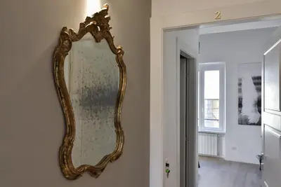 a gold mirror hanging on a wall in a room at B&B Casa Angelini in Rome