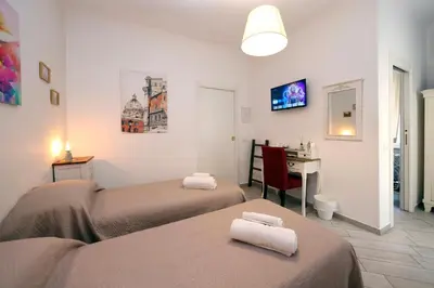 a bedroom with two beds and a desk with a computer at Sivory Rome in Rome