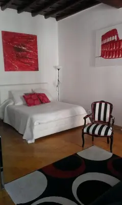 a white bedroom with a bed and a chair at World Wide Bed Piazza del Popolo in Rome