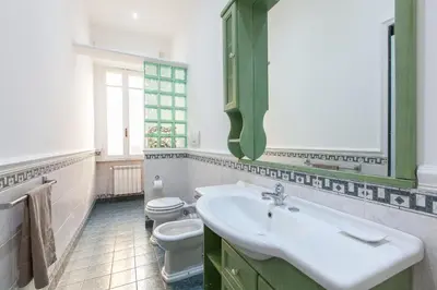 a bathroom with a white sink and a toilet at MamaR Apartment in Rome
