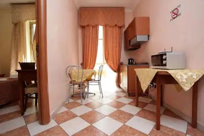 a small room with a kitchen and a table with a microwave at Elegance in Rome