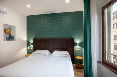 a bedroom with a bed and a green wall at Amalia Suites by Remember Rome in Rome