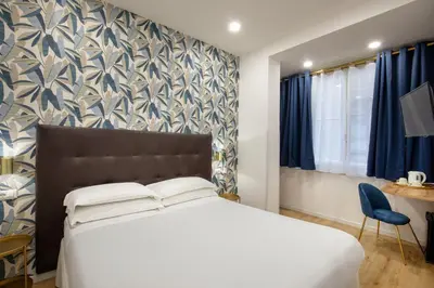 a bedroom with a bed and a blue and white wall at Amalia Suites by Remember Rome in Rome