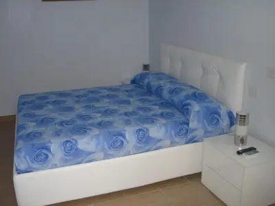 a white bed with a blue comforter on it at Sweet Monte Verde in Rome