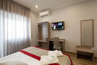 a hotel room with a bed and a desk and a television at Vatican City Relais in Rome