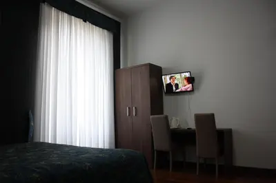 a bedroom with a bed and a desk with a tv at Marziah Inn in Rome