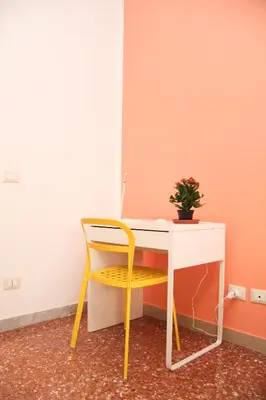 a yellow chair sitting next to a desk with a laptop at Maison Velia in Rome