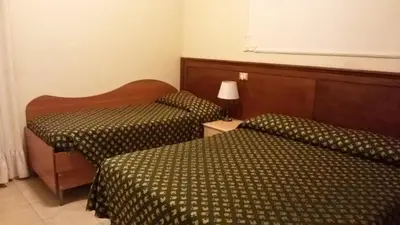 a hotel room with two beds and a lamp at Rosetta in Rome