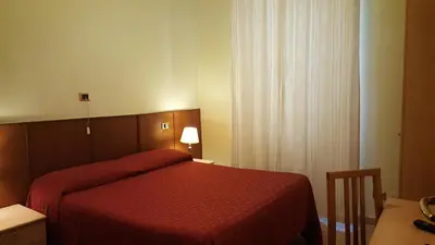 a bedroom with a bed with a red bedspread and a table at Rosetta in Rome