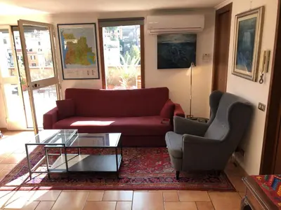 a living room with a red couch and a chair at Angelo Emo Terrace in Rome