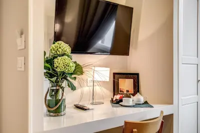 a vase of flowers on a shelf with a mirror at The Club Navona in Rome