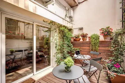 an outdoor patio with tables and chairs and plants at The Club Navona in Rome