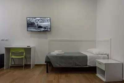 a bedroom with a bed and a desk and a chair at Hotel Bella Vita in Rome