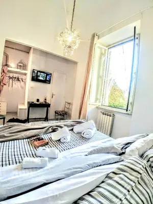two beds in a bedroom with a chandelier at B&B Next Stop in Rome