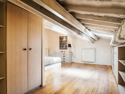 a bedroom with a bed and a wooden floor at Spanish Steps Luxury Penthouse in Rome