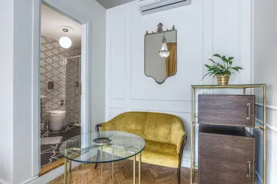a dining room with a glass table and a yellow chair at Ingrami Suites and Spa in Rome