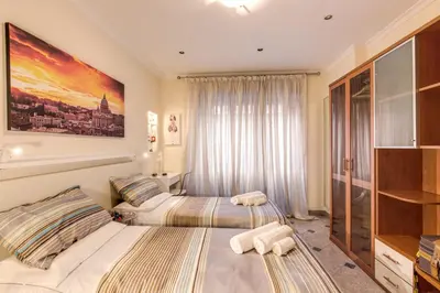 a bedroom with two beds and a large window at Residenza Amoroma in Rome