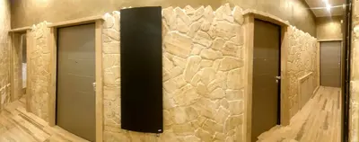 a bathroom with three walk in showers with a stone wall at Jadore Monic in Rome
