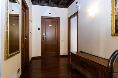 a hallway with a wooden door and a mirror at Domus Julia Trevi - Spagna in Rome