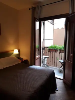 a bedroom with a bed and a door to a balcony at Domus Julia Trevi - Spagna in Rome
