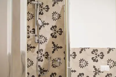 a shower in a bathroom with flowers on the wall at Casa Tommasina in Rome