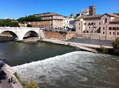 a river in a city with a bridge and buildings at Casa Tommasina in Rome