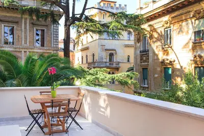 a table and chairs on a balcony with buildings at Casa Tommasina in Rome