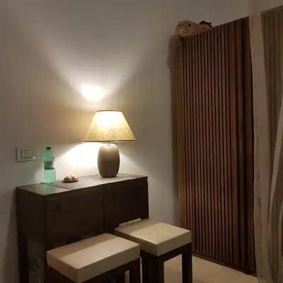 a lamp sitting on top of a table with two stools at Dante in Rome