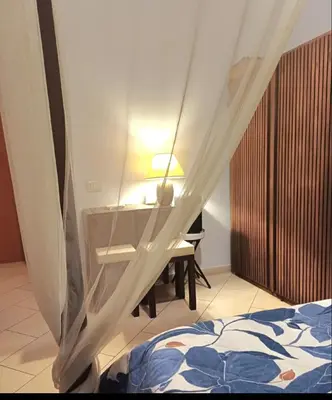 a bedroom with a bed and a desk with a lamp at Dante in Rome