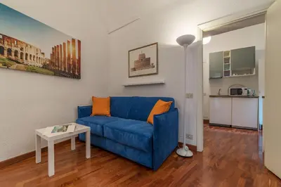 a living room with a blue couch and a table at CS Piazza Venezia Apartment in Rome