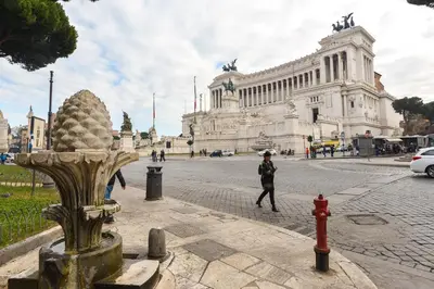 a woman is walking in front of a building at CS Piazza Venezia Apartment in Rome