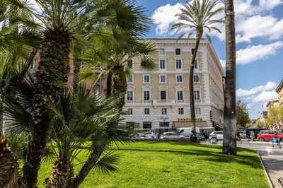 a group of palm trees in front of a building at MyBedCavour in Rome