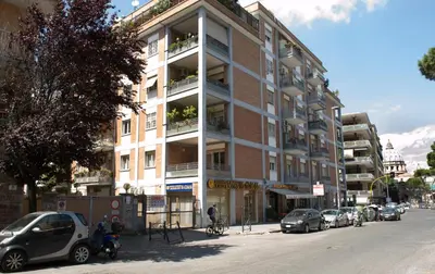 a tall building with cars parked on the side of the street at Dal Pontefice in Rome
