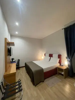 a bedroom with a large bed and a chair at Residenza Cola Di Rienzo - Suite In Rome in Rome