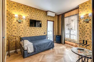 a bedroom with a bed in a room with yellow wallpaper at Residenza Ave Roma in Rome