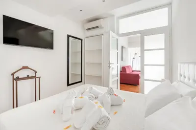 a white bedroom with a bed with towels on it at HOME SWEET HOLIDAY srl in Rome