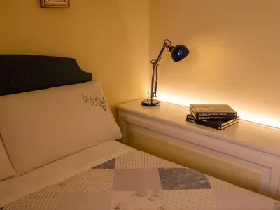 a bedroom with a bed with a lamp and books at Navona Little Home in Rome
