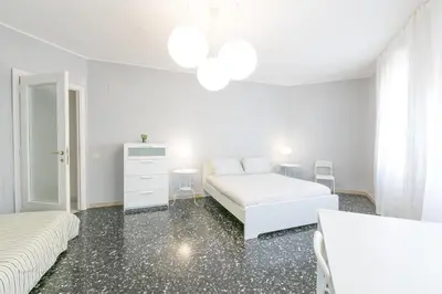 a white bedroom with two beds and a dresser at Domus Klimt in Rome