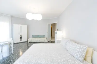 a white bedroom with a bed and a couch at Domus Klimt in Rome