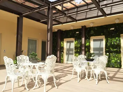 a group of white chairs and tables on a patio at Aeterno Eco Guest House in Rome
