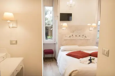 a small bedroom with a bed and a window at Your Vatican Suite in Rome