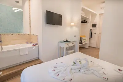 a bathroom with a bed and a tub and a sink at Your Vatican Suite in Rome