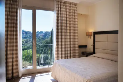 a bedroom with a bed and a large window at Hotel Villa Maria Regina in Rome