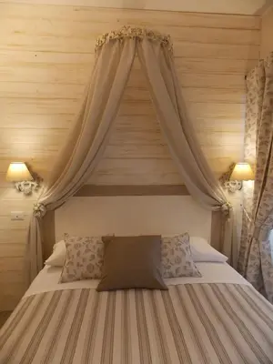 a bedroom with a bed with a canopy at Casa Tua Vaticano Guest House in Rome