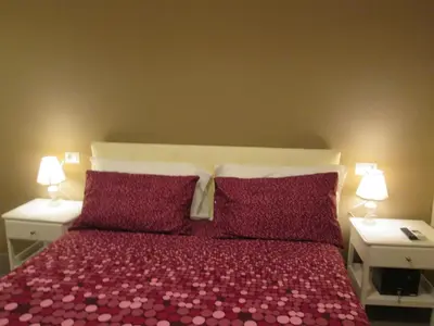 a bedroom with a bed with purple pillows and two lamps at Trevi Elegance Suite in Rome