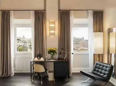 a room with a desk and a chair and windows at Hotel Scalinata Di Spagna in Rome